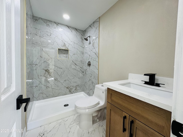 bathroom featuring marble finish floor, vanity, a shower stall, and toilet