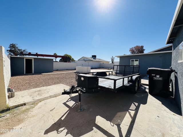 view of patio with fence and an outbuilding