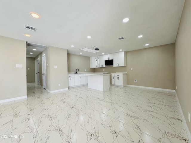 kitchen with white cabinets, visible vents, and open floor plan