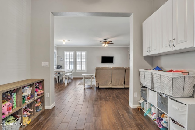 interior space featuring crown molding, ceiling fan, dark hardwood / wood-style floors, and white cabinetry