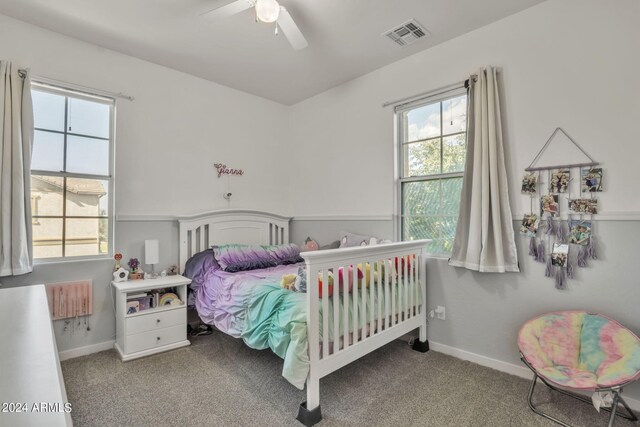 carpeted bedroom with ceiling fan and radiator