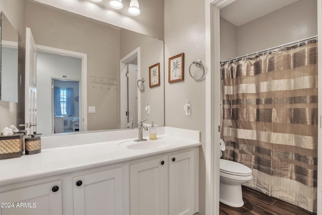 bathroom featuring hardwood / wood-style flooring, vanity, curtained shower, and toilet