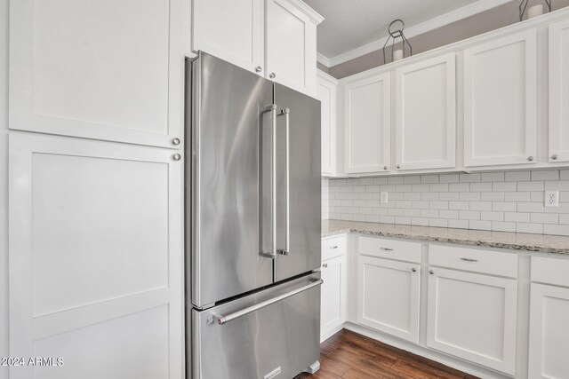 kitchen with high quality fridge, crown molding, dark wood-type flooring, light stone counters, and white cabinets