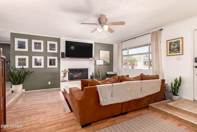 5031 W Grandview Rd, Glendale, AZ 85306 - living room with ceiling fan, light wood finished floors, a brick fireplace, crown molding, and a textured ceiling