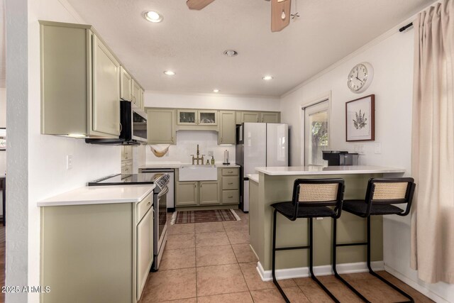 5031 W Grandview Rd, Glendale, AZ 85306 - kitchen featuring appliances with stainless steel finishes, a peninsula, a sink, a breakfast bar, and light countertops