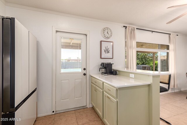 5031 W Grandview Rd, Glendale, AZ 85306 - kitchen featuring a peninsula, light tile patterned floors, healthy amount of natural light, light countertops, and ornamental molding
