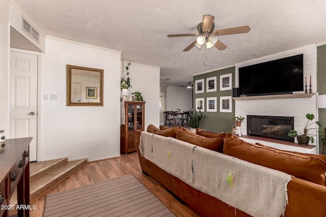5031 W Grandview Rd, Glendale, AZ 85306 - living room featuring a ceiling fan, wood finished floors, a brick fireplace, and a textured ceiling