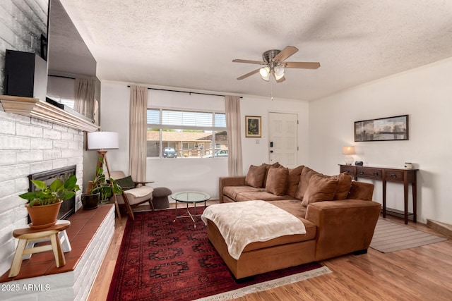 5031 W Grandview Rd, Glendale, AZ 85306 - living room with wood finished floors, a ceiling fan, a textured ceiling, and a brick fireplace