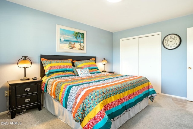 carpeted bedroom with a closet and baseboards