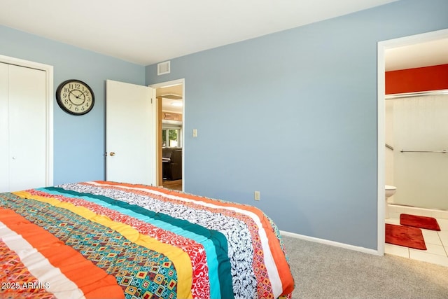 bedroom with baseboards, visible vents, connected bathroom, carpet flooring, and a closet