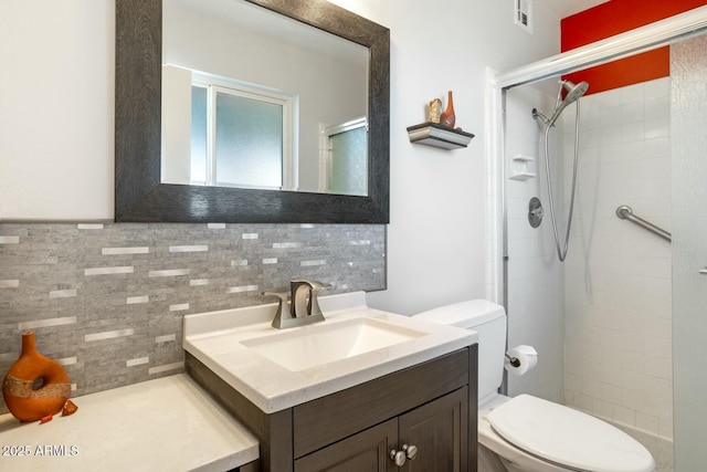 bathroom with visible vents, decorative backsplash, toilet, a shower stall, and vanity