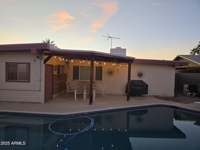 back house at dusk featuring a patio