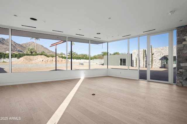 unfurnished sunroom with plenty of natural light and a mountain view