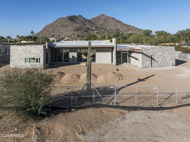 back of house with fence, a mountain view, and stucco siding