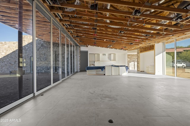 interior space with vaulted ceiling, plenty of natural light, and floor to ceiling windows