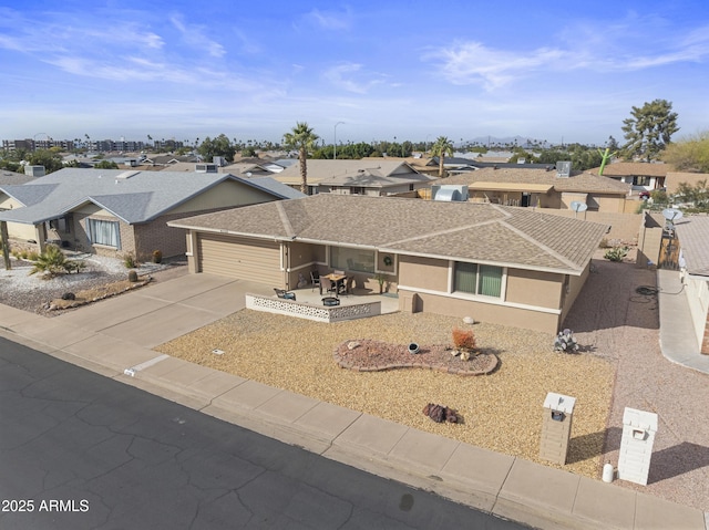 ranch-style home with a garage and a patio