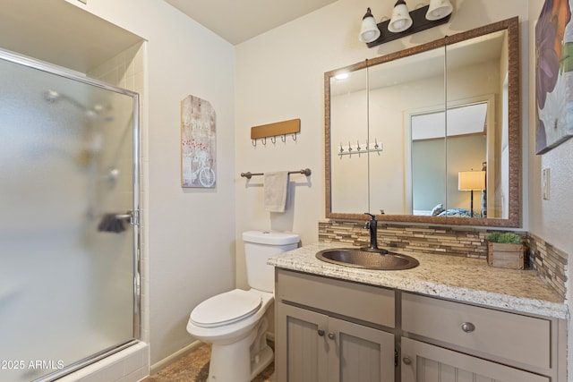 bathroom with vanity, toilet, an enclosed shower, and backsplash