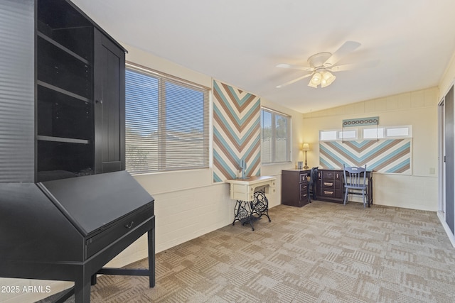 office area featuring lofted ceiling, light carpet, and ceiling fan