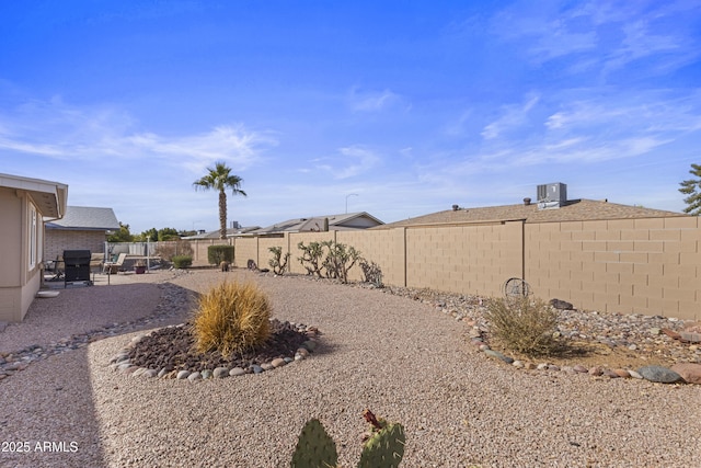 view of yard with central AC and a patio area