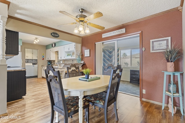 dining space with ornamental molding, independent washer and dryer, ceiling fan, a textured ceiling, and light hardwood / wood-style flooring