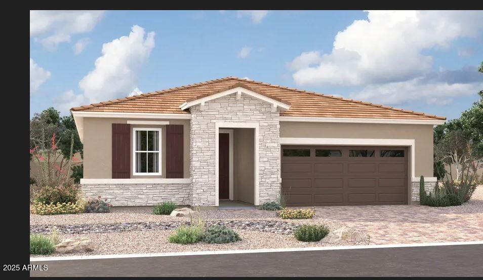 5006 W Hardtack Trl, Laveen, AZ 85339 - view of front of property featuring stone siding, an attached garage, driveway, and stucco siding