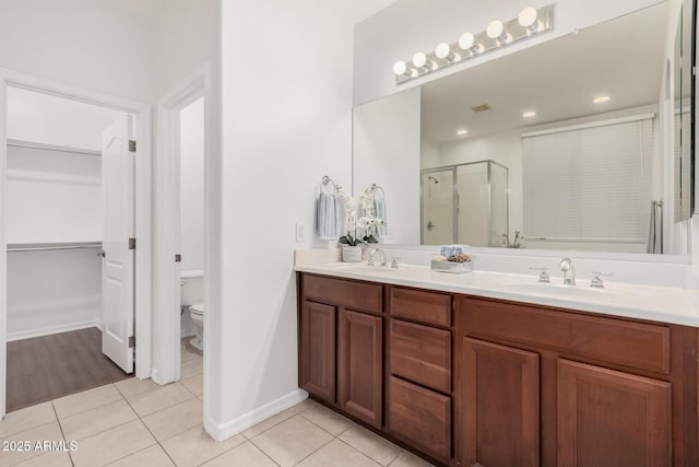 bathroom with tile patterned floors, walk in shower, vanity, and toilet