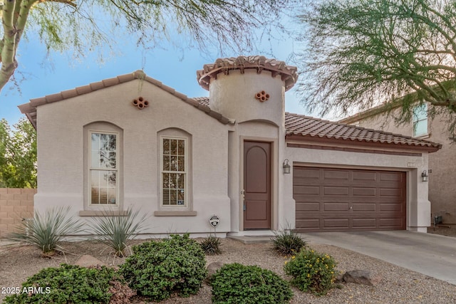 mediterranean / spanish-style home featuring a garage, driveway, a tiled roof, and stucco siding