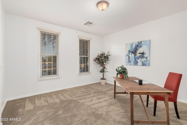 carpeted office space with visible vents and baseboards