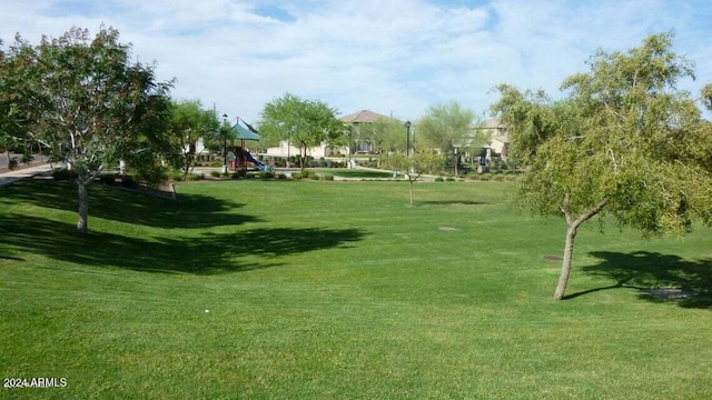 surrounding community with playground community and a lawn