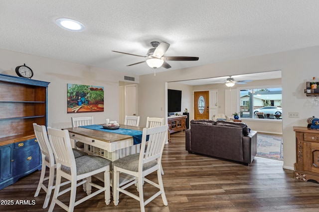 dining space featuring visible vents, wood finished floors, a textured ceiling, and ceiling fan