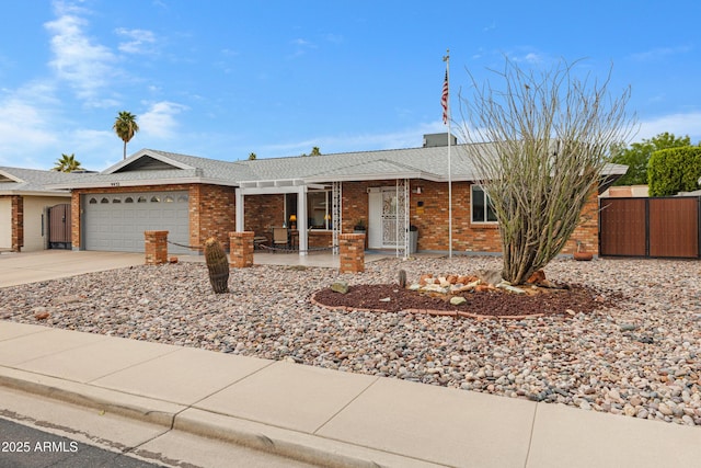 ranch-style house featuring brick siding, a porch, driveway, an attached garage, and a gate