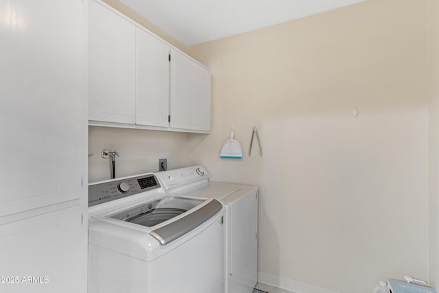 clothes washing area featuring cabinet space, independent washer and dryer, and baseboards