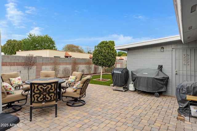 view of patio featuring a grill and fence