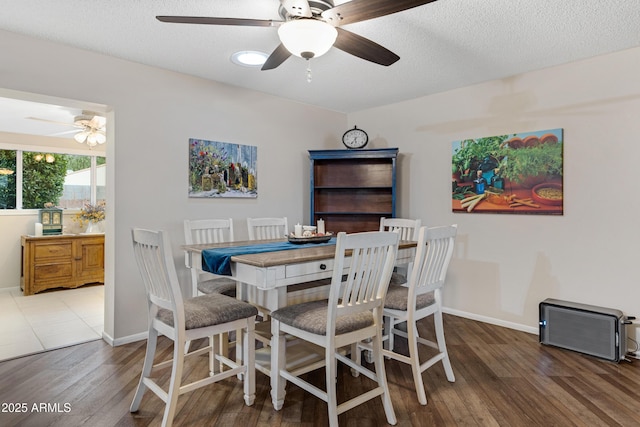 dining room featuring a textured ceiling, wood finished floors, baseboards, and ceiling fan