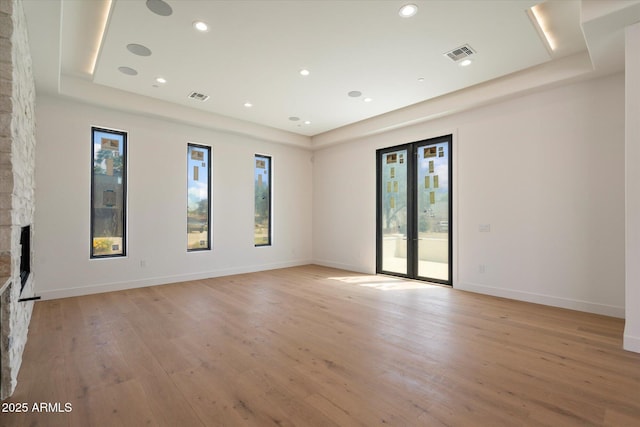 6202 E Larkspur Dr, Scottsdale, AZ 85254 - unfurnished room with a raised ceiling, light wood-style floors, a stone fireplace, baseboards, and recessed lighting