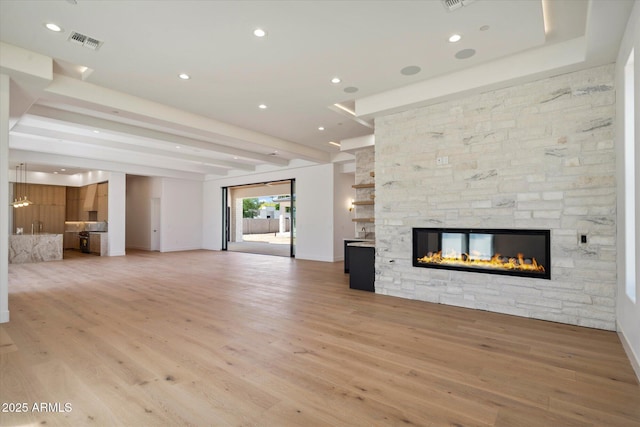 6202 E Larkspur Dr, Scottsdale, AZ 85254 - unfurnished living room featuring a fireplace, light wood-type flooring, recessed lighting, and beamed ceiling