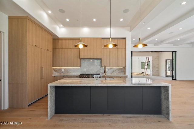6202 E Larkspur Dr, Scottsdale, AZ 85254 - kitchen with a sink, modern cabinets, light stone countertops, tasteful backsplash, and light wood-style flooring