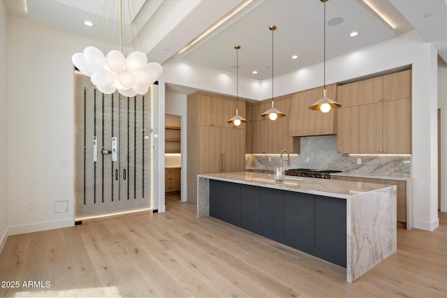 6202 E Larkspur Dr, Scottsdale, AZ 85254 - kitchen featuring modern cabinets, decorative backsplash, light wood-style floors, a large island with sink, and recessed lighting