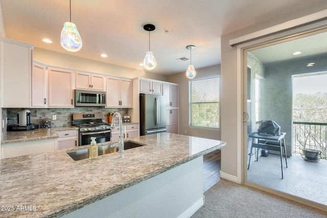 kitchen featuring stainless steel appliances, a healthy amount of sunlight, visible vents, and white cabinetry