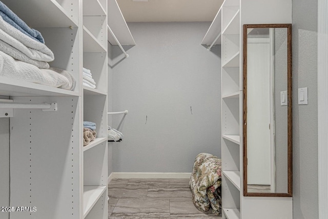 walk in closet with light hardwood / wood-style floors