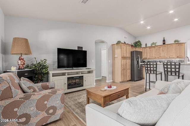 living room featuring light hardwood / wood-style flooring and lofted ceiling