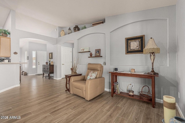 living area with light hardwood / wood-style flooring and vaulted ceiling