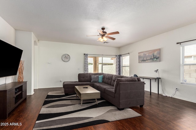 12371 W Hadley St, Avondale, AZ 85323 - living room featuring ceiling fan, a textured ceiling, baseboards, and dark wood-style floors