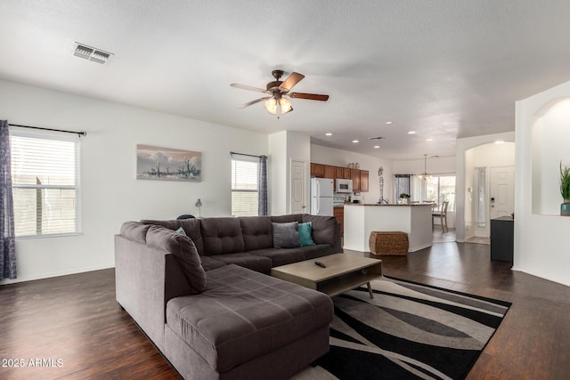 12371 W Hadley St, Avondale, AZ 85323 - living room with arched walkways, dark wood-style flooring, ceiling fan, and visible vents