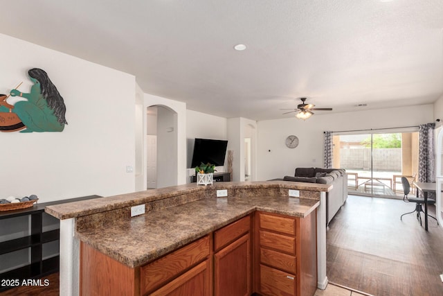 12371 W Hadley St, Avondale, AZ 85323 - kitchen with brown cabinets, open floor plan, a ceiling fan, and arched walkways