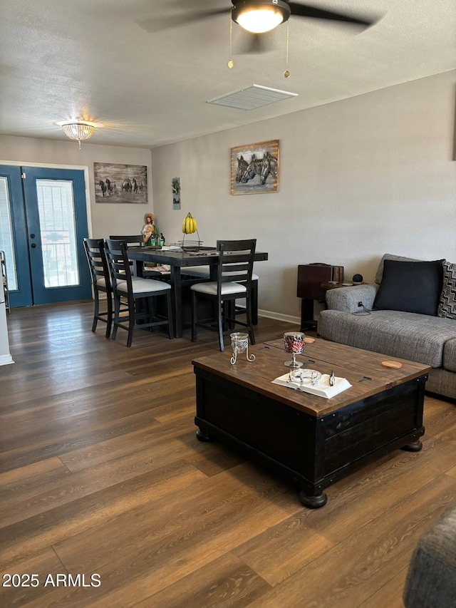 living room featuring ceiling fan and dark hardwood / wood-style flooring