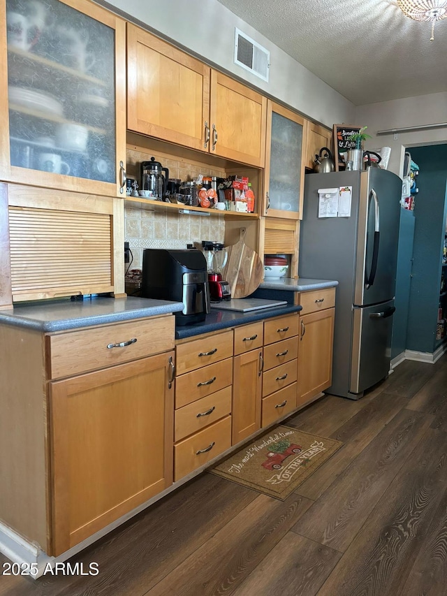 kitchen featuring a textured ceiling, dark hardwood / wood-style floors, and stainless steel fridge