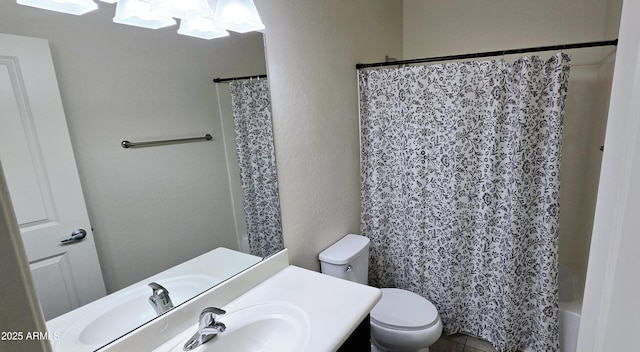 bathroom with shower / bath combination with curtain, a textured wall, vanity, and toilet