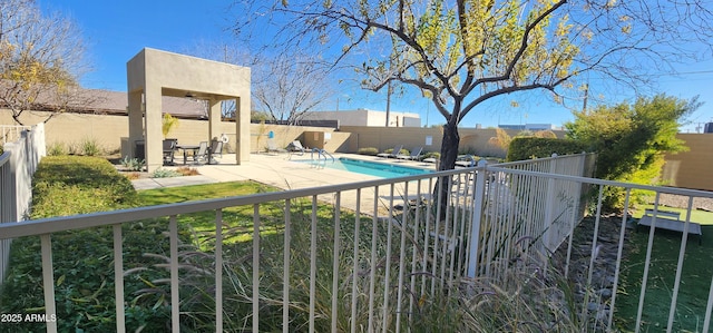 community pool with a patio area and a fenced backyard