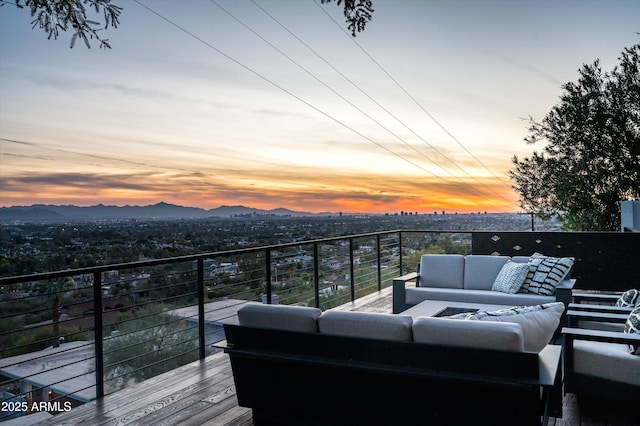 deck at dusk featuring an outdoor living space and a mountain view